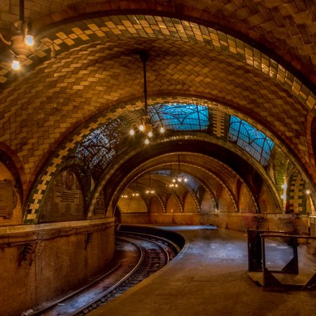 Abandoned Brooklyn, New York Old City Hall Subway Station with amethyst glass skylights, Gustavino tiled arched ceiling and walls, curved subway tracks and brass chandeliers