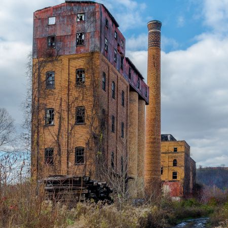 Abandoned brick distillery with broken windows and smokestack in Pennsylvania