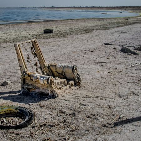 Abandoned chair and tires on Salton Sea beach, California.