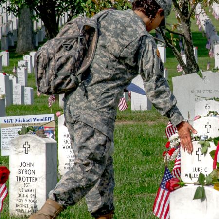 Soldier paying tribute to a fallen at Arlington National Cemetery on Memorial Day.