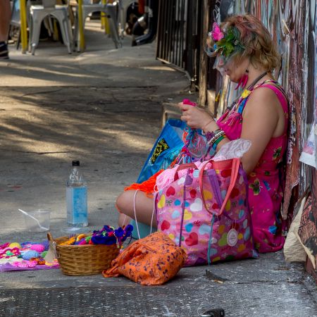 Women selling and creating homemade crochet items on sidewalk in Brooklyn, New York City.