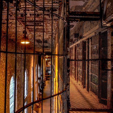 Abandoned Ohio State Penitentiary upper level cell block with bars and windows.