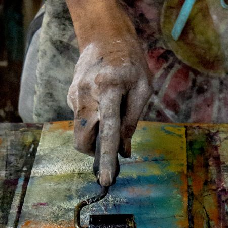 Cuban artist's hand rolling ink on paper inside art studio in Havana.