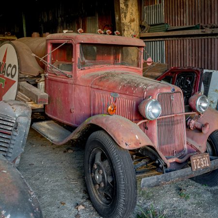 Red Ford Model A truck with vintage Texaco sign and vintage grill.