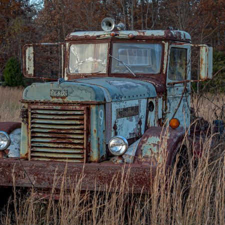 Rusted and peeling 1940s Peterbilt Truck with cracked window and in field of wheat