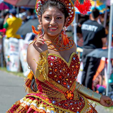 Portrait of woman in traditional dress and feathered hat at Pro Bolivian Festival event