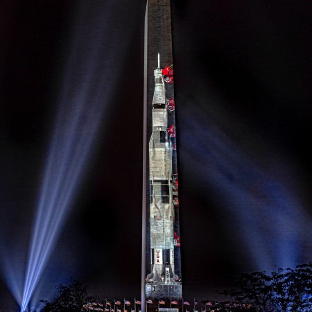 Washington Monument celebrating fiftieth anniversary of Apollo 11 moon launch with projection of Saturn moon rocket.