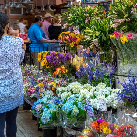 Eastern Market on Capitol Hill with colorful flowers and mother holding infant.