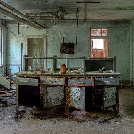 Abandoned hospital pharmacy section with compounding table.