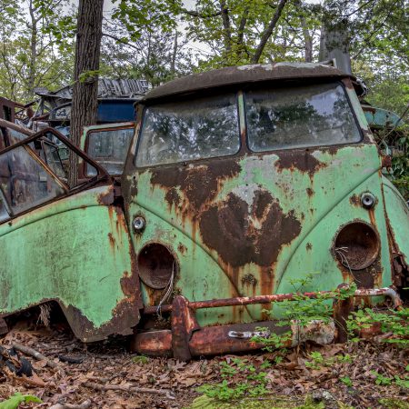 Vintage 1960s green Volkswagen VW counterculture bus with advanced rust.