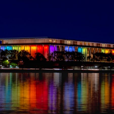 Kennedy Center at blue hour and Illuminated with rainbow of color for annual Honors Event.