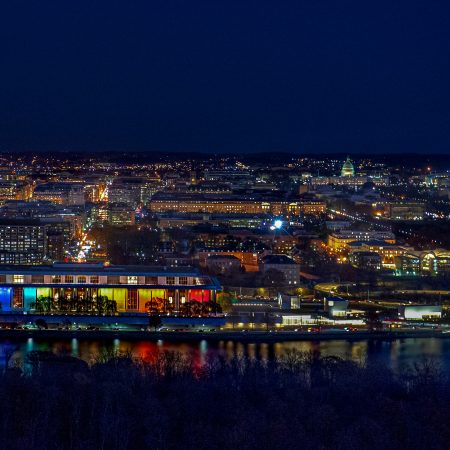 Blue hour night landscape view of Washington D.C. with Kennedy Center rainbow illumination, Washington Monument and Capitol.