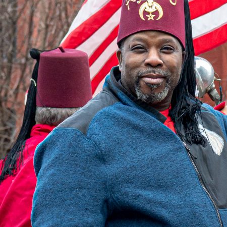 Street portrait of shriner with red fez.