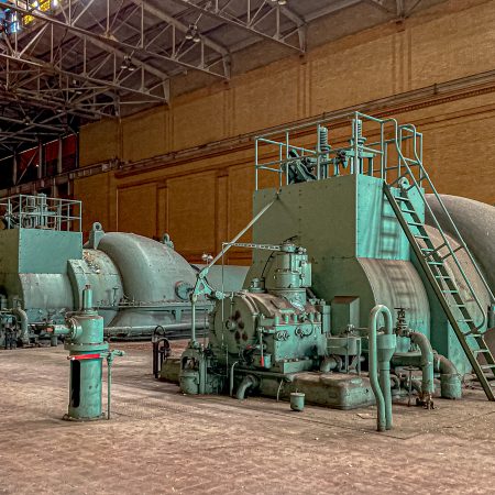 The green turbines sit silently in a decommissioned coal-fired power plant.