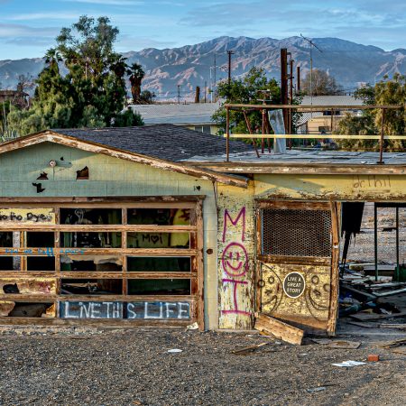 A former home on the edge of Bombay Beach of Salton Sea California with graffiti adorning the home frame.