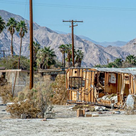 Derelict trailers and housing decomposes on former community beach property of Salton City California.